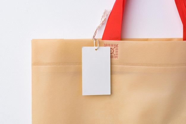 Blanco papieren label met shopper paperbag op witte achtergrond