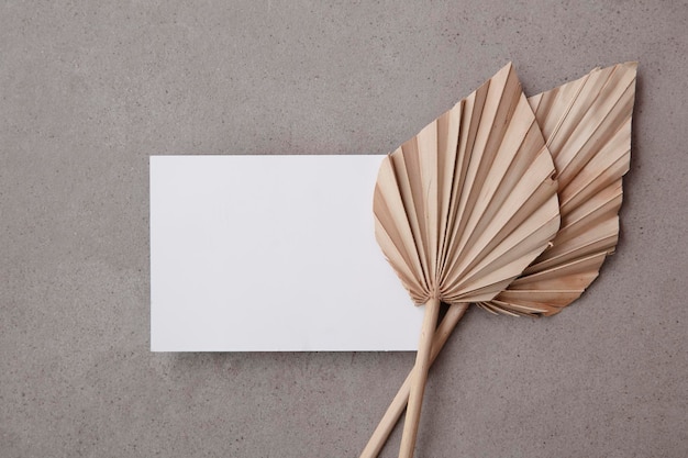 Blanco uitnodigingskaart voor een natuurlijk bruilofts- of feestevenement met gedroogde palmbladstam