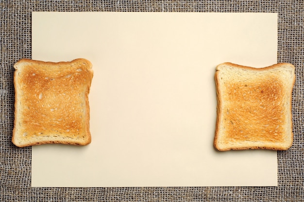 Blanco vel geel papier en twee sneetjes toastbrood