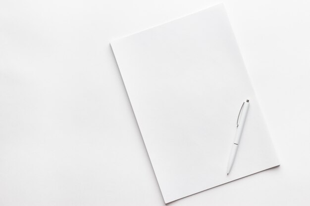 Blanco vel papier op de witte tafel met een pen