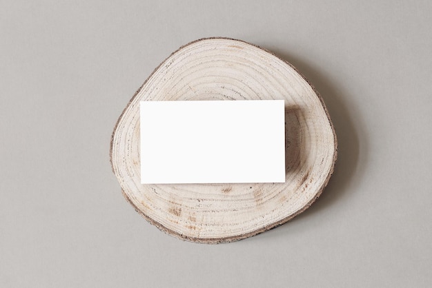 Blanco witte visitekaartje mockup op houten plaat chop board grijze tafel achtergrondkleur moderne minimalistische sjabloon branding identiteit natuurlijke winter ontwerp plat lag bovenaanzicht