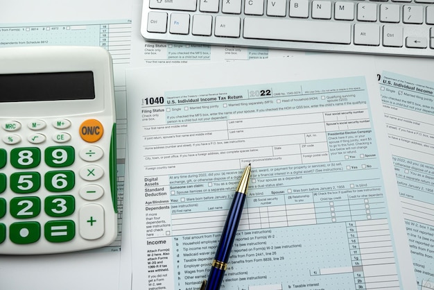 Blank 1040 US Individual income tax return form 2022 with pen calculator and computer keyboard Deadline paperwork concept