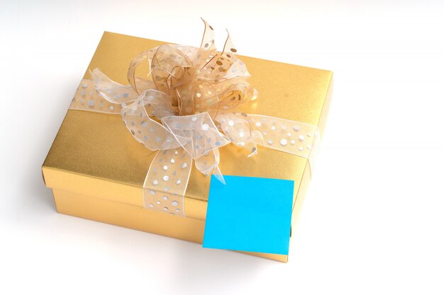 Blank adhesive note on gold gift box on white