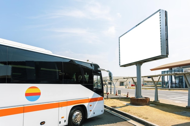 Blank advertising billboard in the airport Tour bus parked near airport Ad travel concept