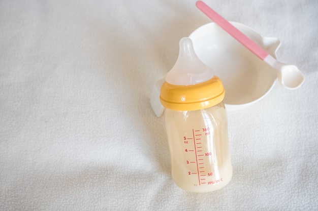 Photo blank baby bowl , spoon and bottle of mother breast milk