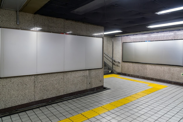 Tabellone per le affissioni in bianco situato nel corridoio sotterraneo o metropolitana per la pubblicità, concetto di mockup