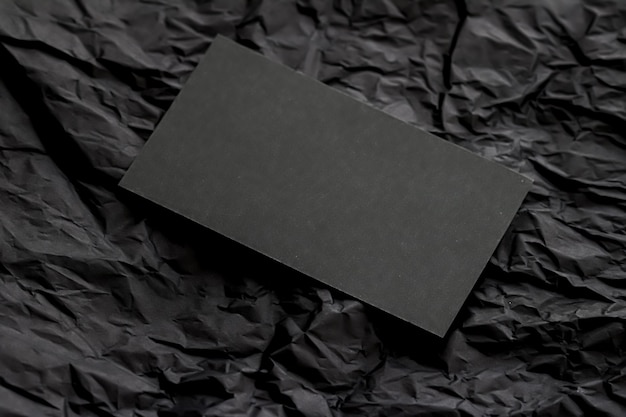 Blank black business card for mockup on dark flatlay background luxury branding and corporate identi...