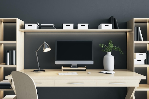 Blank black computer monitor screen with lamp and vase on wooden desk table in eco style interior room Mock up