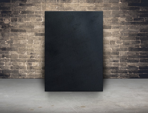 Blank black fabric canvas frame at grunge brick wall and concrete floor background