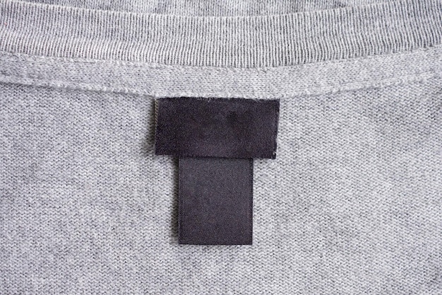 Blank black laundry care clothing label on fabric texture