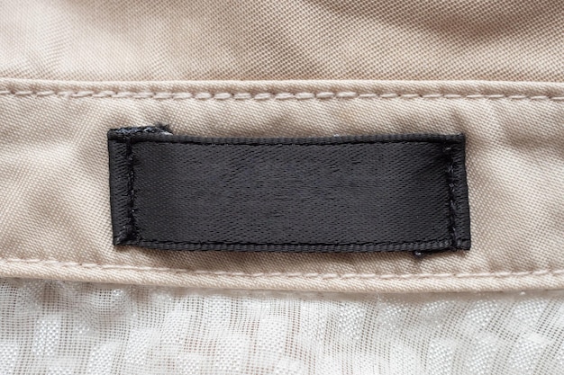 Пустая черная этикетка для одежды по уходу за стиркой на текстуре ткани