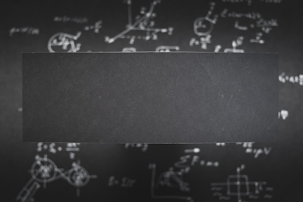 Photo blank black paper with space for text blurred background with science formula and equation