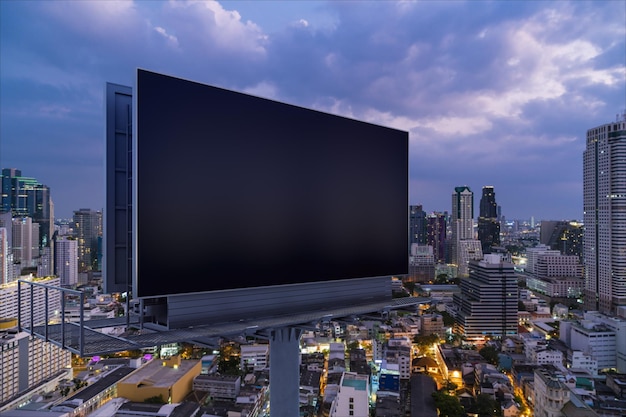 Blank black road billboard with bangkok cityscape background at\
night time street advertising poster mock up 3d rendering side view\
the concept of marketing communication to promote idea