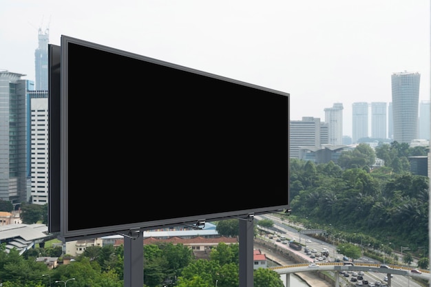 昼間のクアラルンプールの街並みの背景を持つ空白の黒い道路看板ストリート広告ポスターモックアップ3Dレンダリング側面図マーケティングコミュニケーションの概念