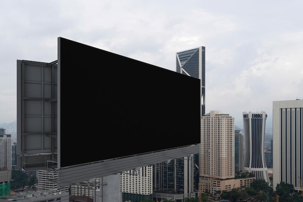 Blank black road billboard with Kuala Lumpur cityscape background at day time Street advertising poster mock up 3D rendering Side view The concept of marketing communication