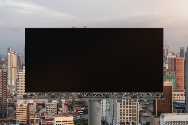 Blank black road billboard with Kuala Lumpur cityscape background at sunset Street advertising poster mock up 3D rendering Front view The concept of marketing communication to sell idea