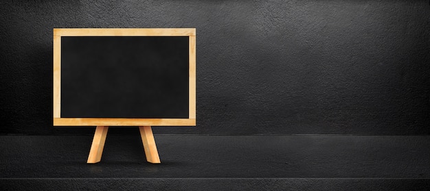 Blank blackboard leaning at black interior cement room background
