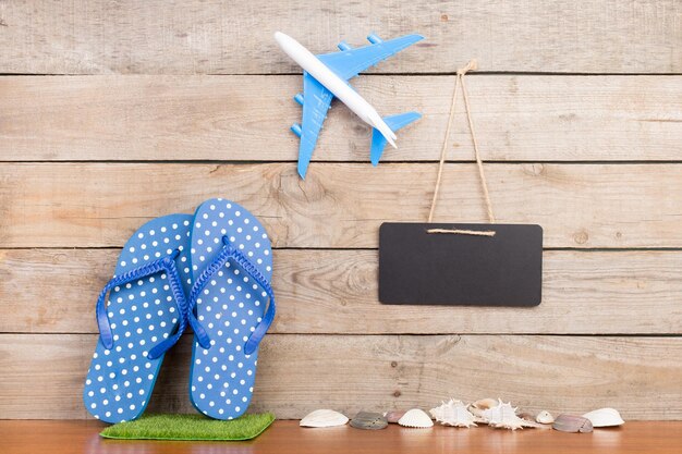 Blank blackboard plane seashells on brown wooden background