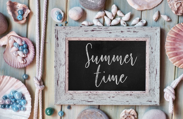 Photo blank blackboard with text summer time, sea shells, rope and star fish on pale mint green wooden planks