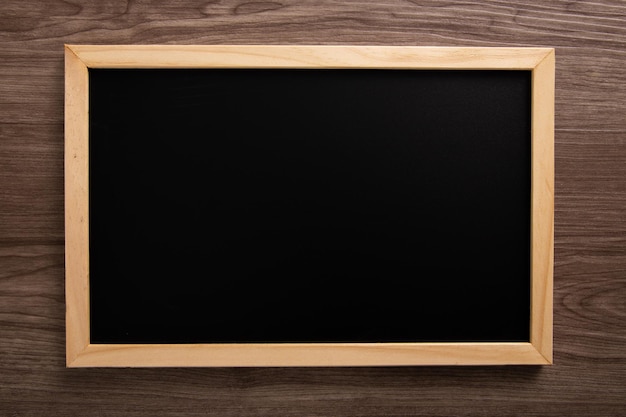 Blank blackboard on wooden background