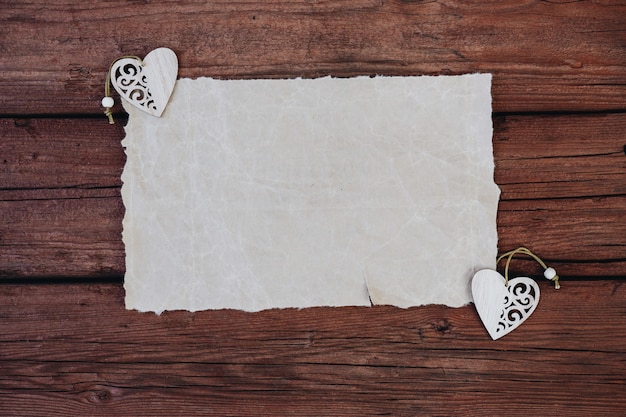 Blank or blank paper with wooden hearts on a wooden background Space for text cpy space