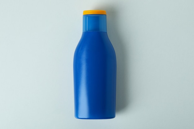 Blank blue bottle of sunscreen on white isolated background