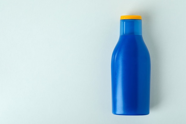 Blank blue bottle of sunscreen on white