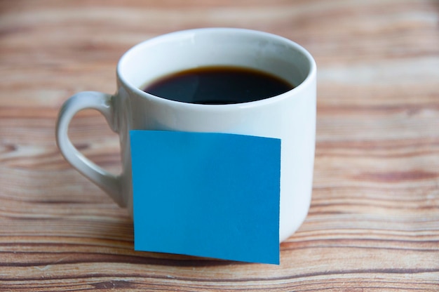 Blank blue notepad stick on coffee cup with customizable space for text or ideas Copy space concept