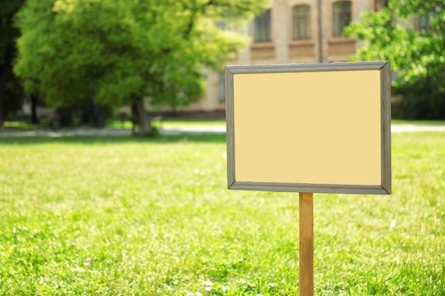 Photo blank board on green lawn in park