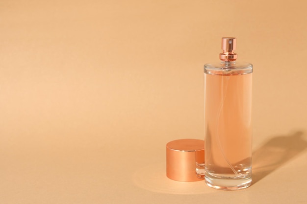 Blank bottle of perfume on beige background