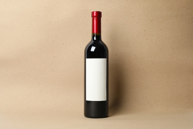 Blank bottle of wine on craft background, space for text