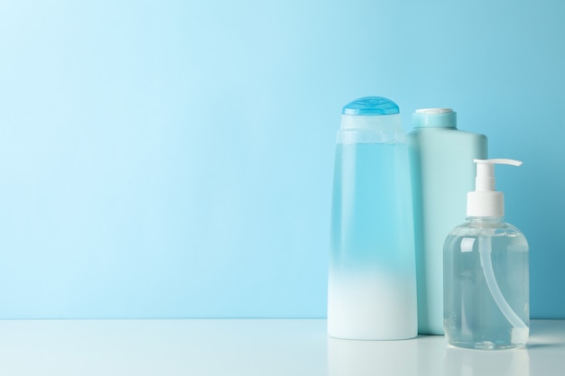 Blank bottles for cosmetics on blue background