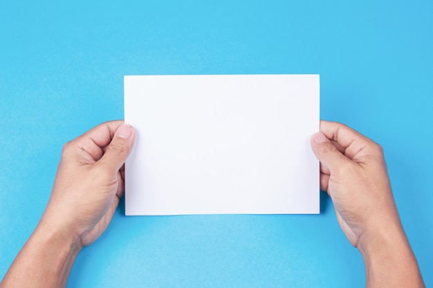 Blank brochure with blank in hand on blue background.