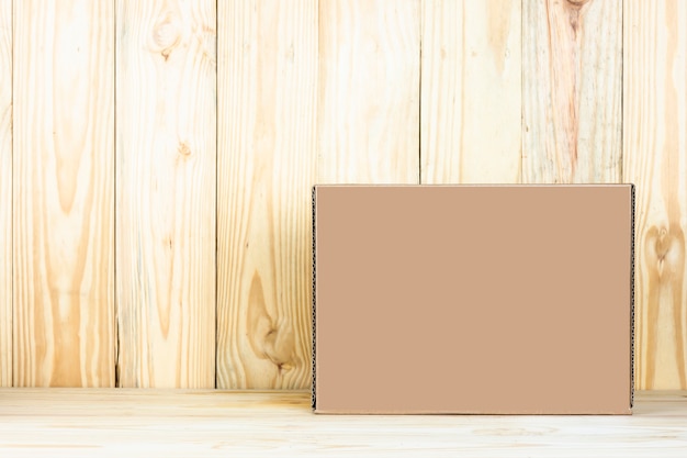 Photo blank brown box on wooden table.