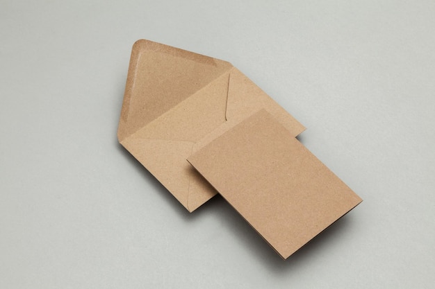 Blank brown kraft paper card and envelope on a grey background