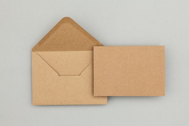 Photo blank brown kraft paper card and envelope on a grey background