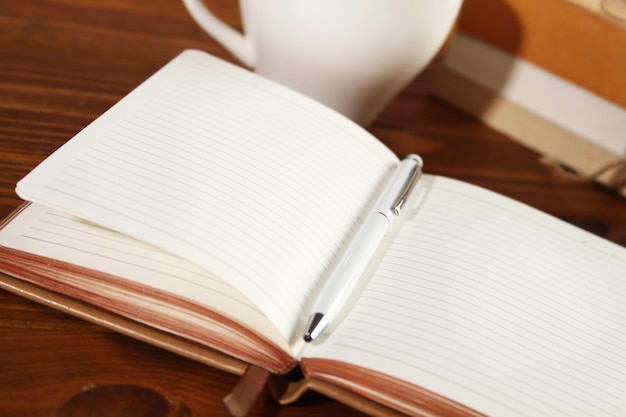 Blank brown notepad on a brown wooden table Business Wallpaper