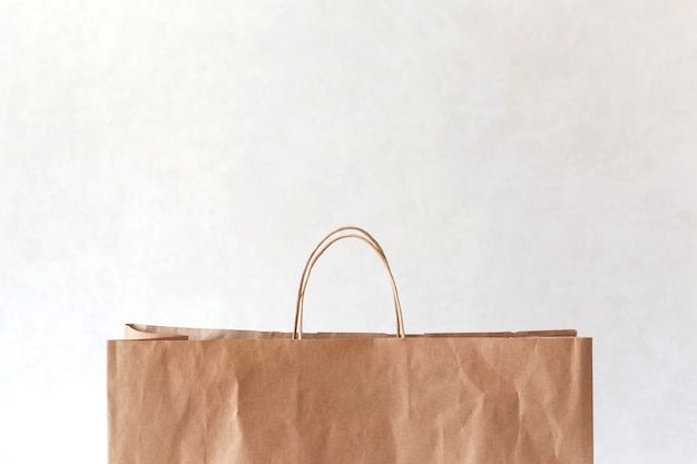 Blank brown paper bag with copy space on top on light.