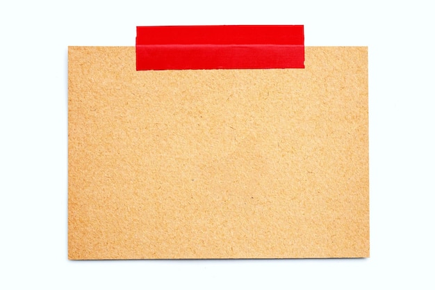 白い背景の上の赤い電気テープと空白の茶色の紙