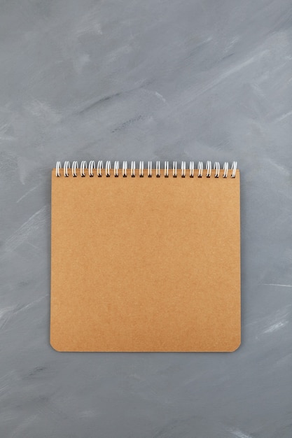 Blank, brown spiral notebook cardboard sheet on grey