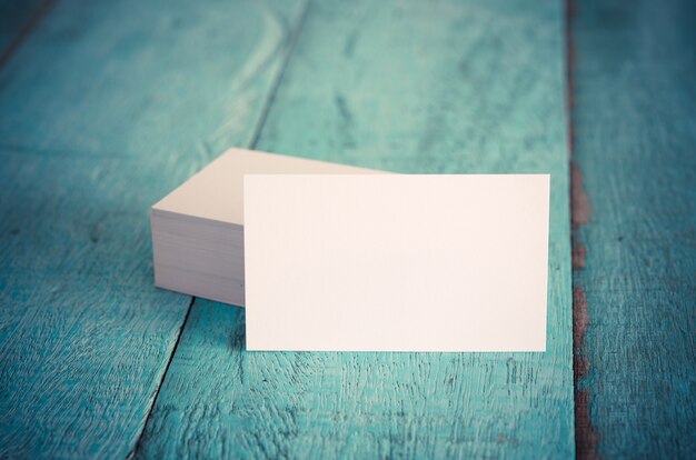 Blank business cards on blue wooden table.