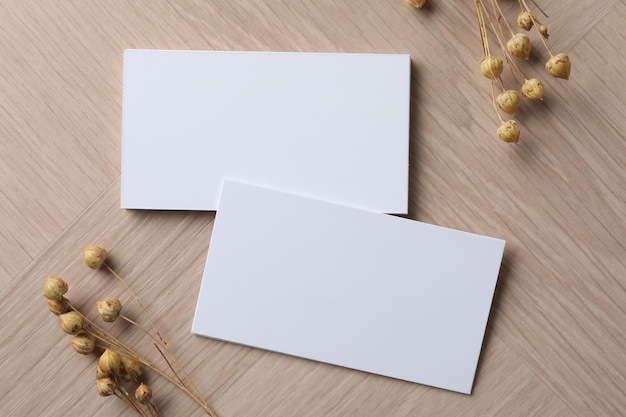 blank business cards and dried herbs on wooden table flat lay mockup for design