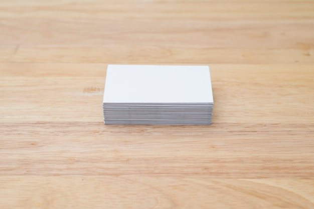 blank business cards stack up on wooden table