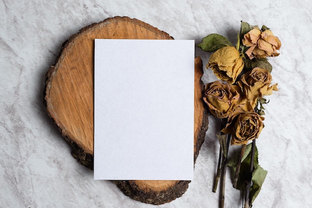 Photo blank card and wilted flowers on marble background