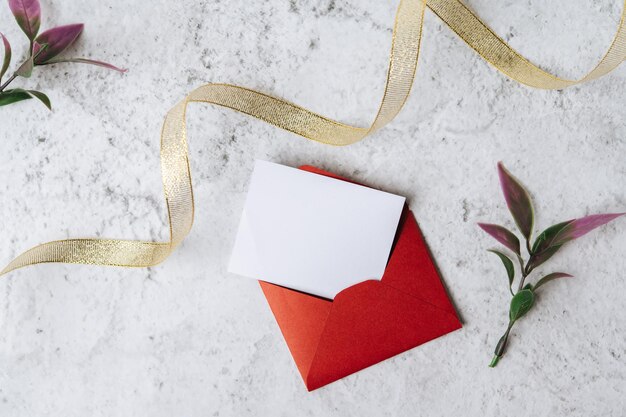 Photo a blank card with red envelope and leaf is placed on white background