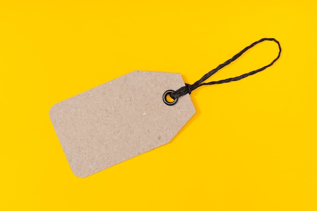 Blank cardboard tag isolated on yellow background template mock up