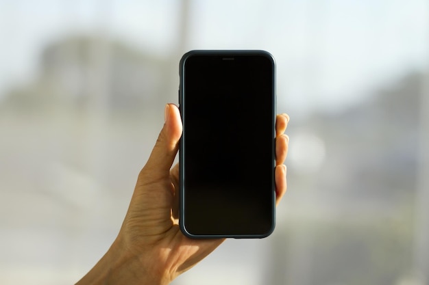 Blank cell phone screen in a female hand mockup