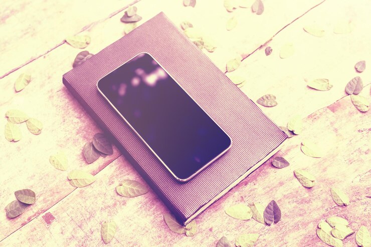 फोटो blank cell phone screen with diary and leaves on wooden table