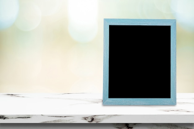 Blank chalkboard standing on table over blur cafe with bokeh background