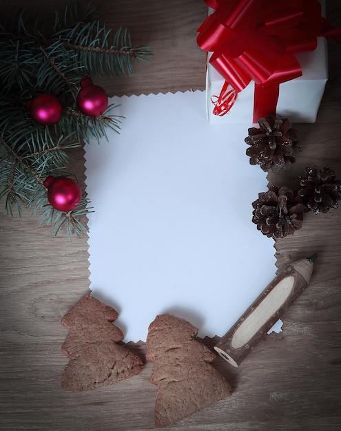 Foto cartolina di natale in bianco e una scatola con un regalo su sfondo di natale